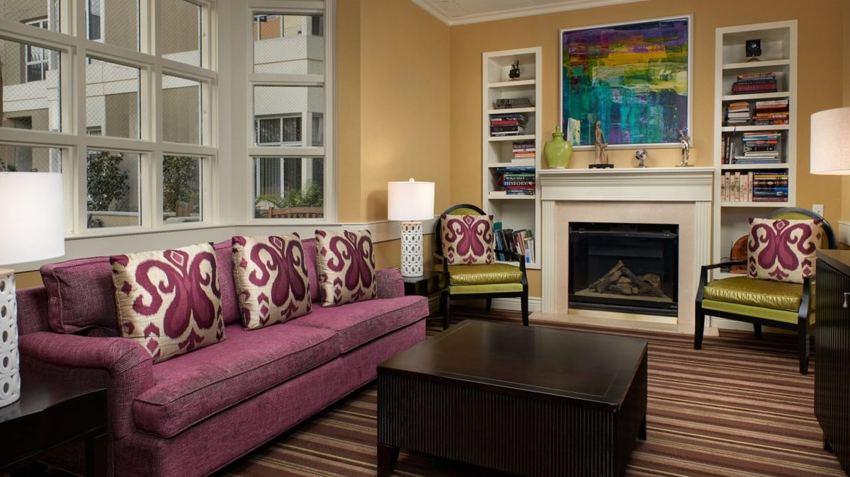 Senior living room at Ivy Park at Cathedral Hill with cozy furniture and fireplace.