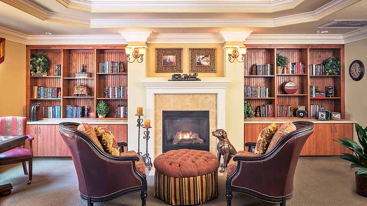 Interior view of Atria Carmichael Oaks senior living community featuring a cozy fireplace, elegant furniture, and home decor.