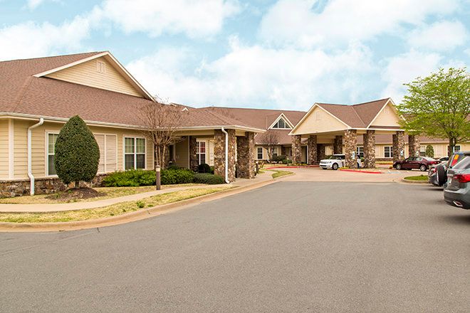 Senior living community, Brookdale Chenal Heights, in a suburban neighborhood with cars for transportation.
