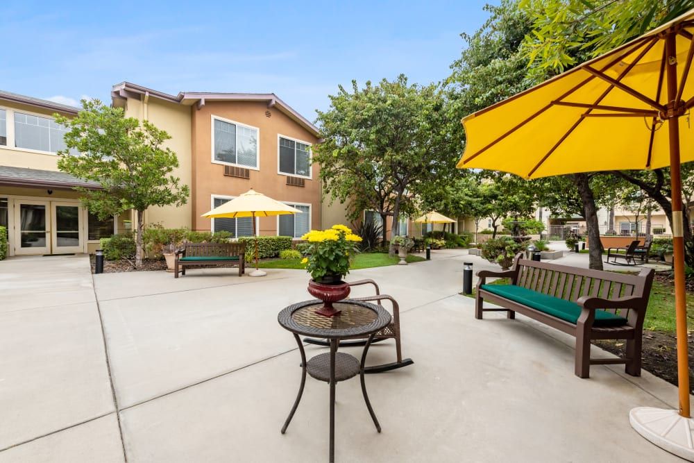 Senior living community, Cypress Place, featuring patio furniture, lush greenery, and suburban architecture.