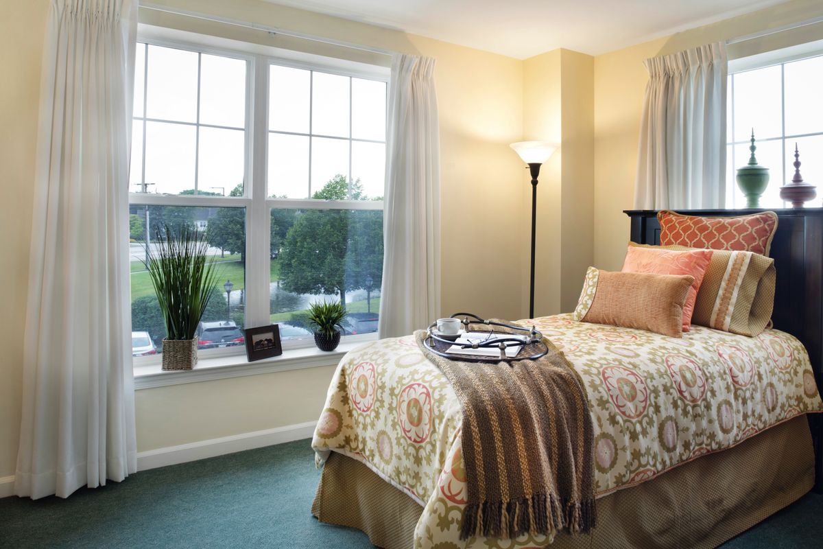 Interior design of a bedroom in Sunrise of Buffalo Grove senior living community with art and decor.