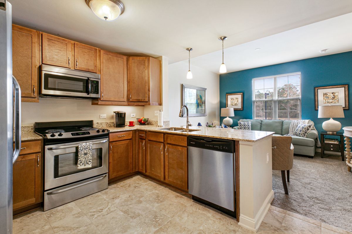 Interior view of St. Anthony's Gardens senior living community featuring a well-equipped kitchen and cozy furniture.