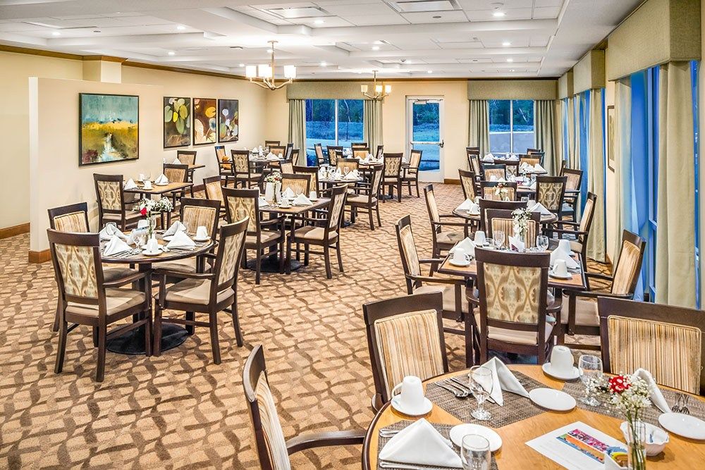 Senior living community, The Sheridan At Tyler Creek, featuring dining room with art and lounge.