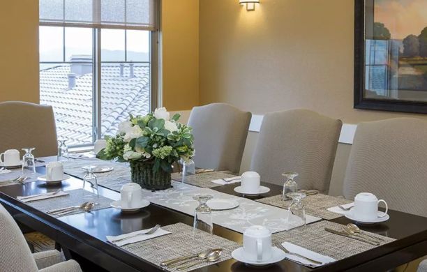 Interior view of Brightwater Senior Living with dining room furniture, table settings, and home decor.