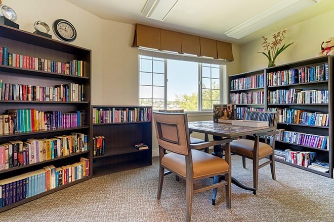 Interior view of Brookdale Auburn senior living community library with furniture and books.
