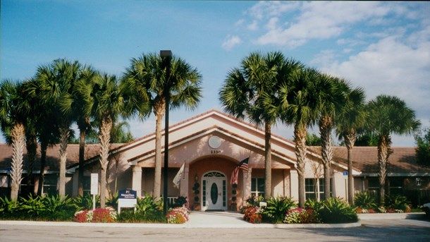 Arden Courts senior living community in West Palm Beach, featuring villa-style housing and lush vegetation.