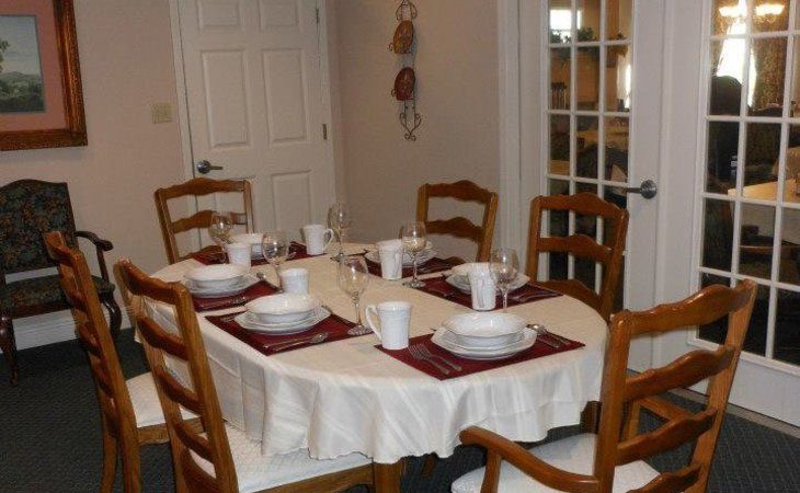 Seniors enjoying a meal in the elegant dining room at Windsor Senior Living Community.