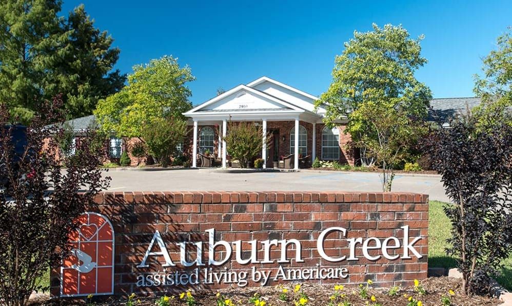 Seniors enjoying outdoor activities at Auburn Creek Assisted Living amidst lush greenery.