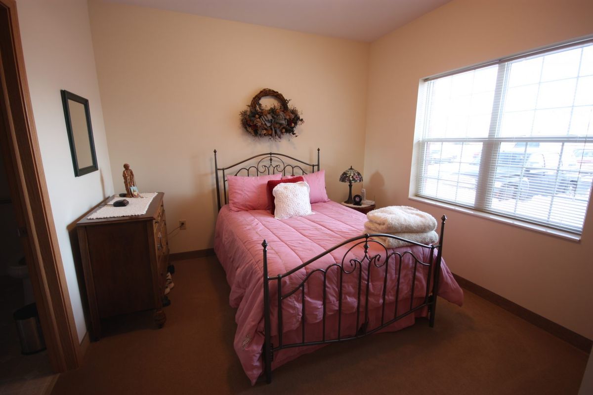 Interior view of a furnished bedroom at Heritage Woods of South Elgin senior living community.