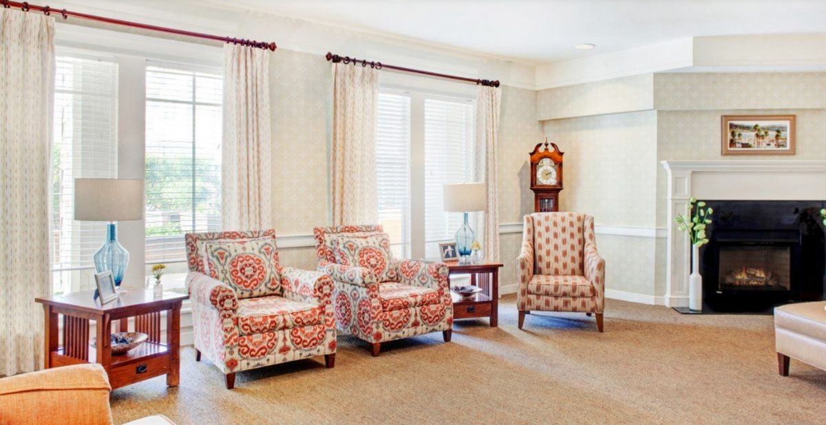 Senior living community room at Hermosa Beach with modern decor, furniture, and fireplace.