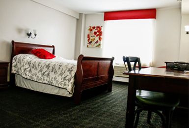 Interior view of a well-furnished bedroom in Signature Senior Living community.