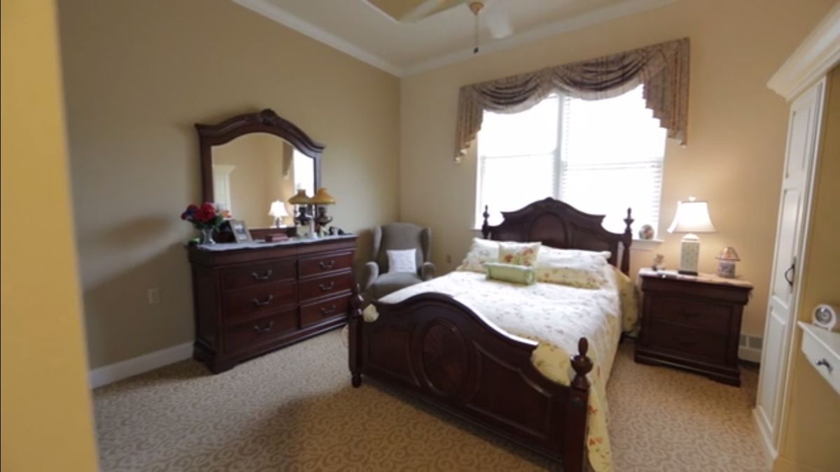 Interior design of a cozy bedroom at Harmony Village at CareOne Stanwick Road senior living community.