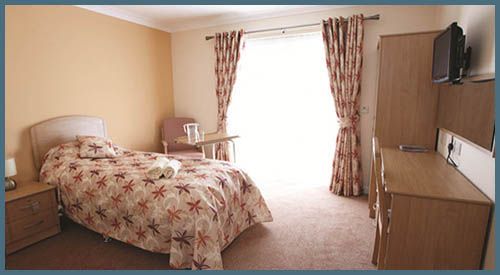 Interior view of a furnished bedroom in South Bay Senior Living community with modern amenities.
