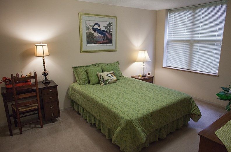Senior living bedroom interior at Presence Bethlehem Woods, La Grange, featuring art and bird decor.