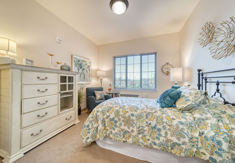 Interior design of a bedroom in The Woodlake senior living community featuring furniture and home decor.