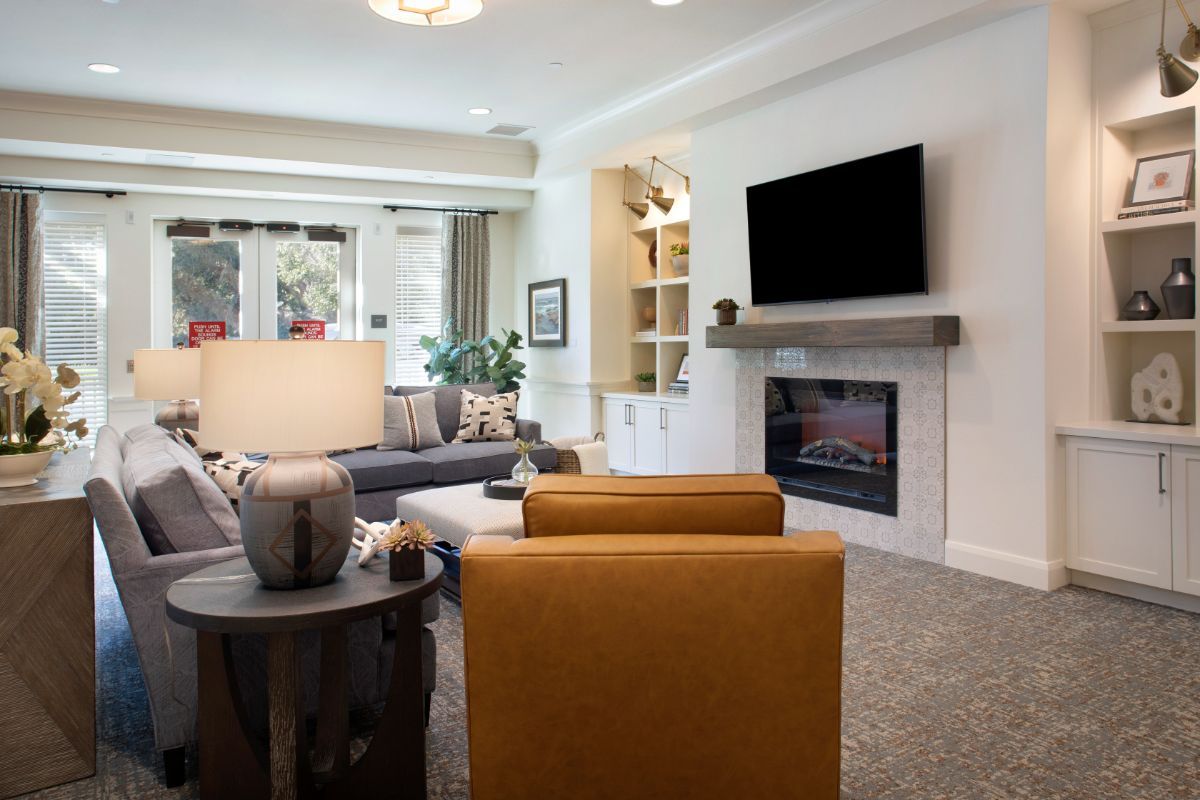 Interior view of Oakmont of Redwood City senior living room with modern decor, furniture, and electronics.