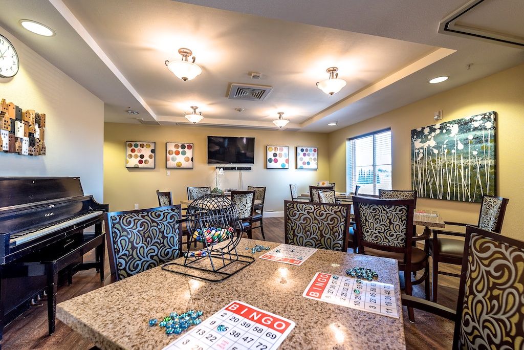 Interior view of Pacifica Senior Living Union City featuring dining area, piano, and modern decor.