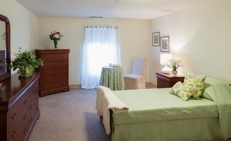 Senior living room at Langdon Place of Exeter with furniture, art, and flower decor.