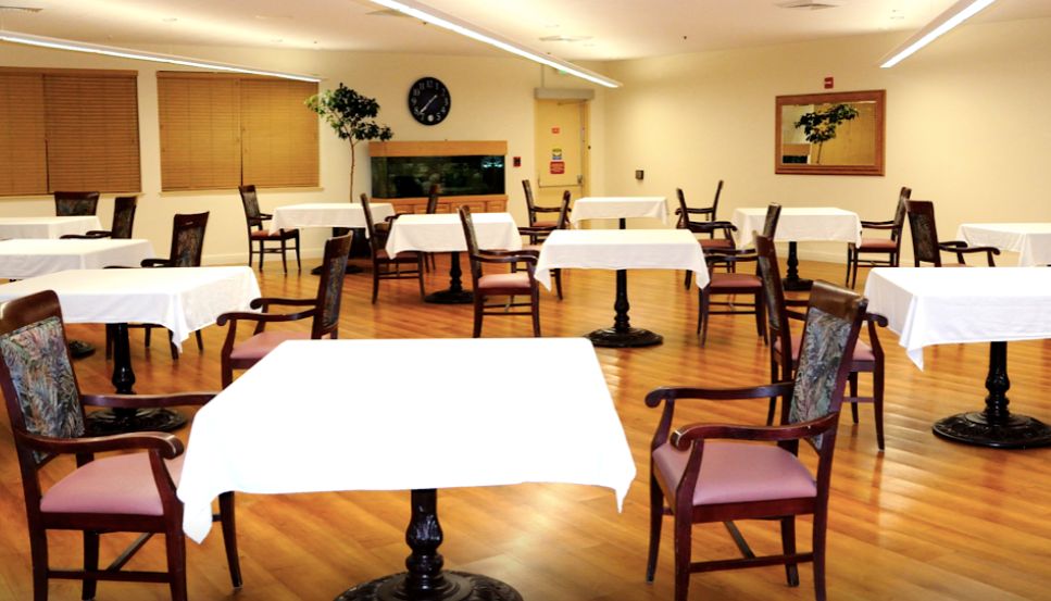 Indoor dining area with wooden furniture at ACC Care Center senior living community.
