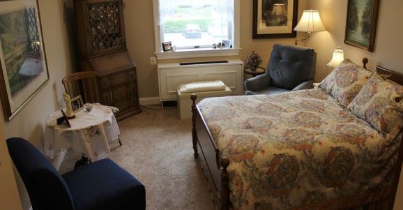 Senior resident at Wiley Christian Living community, in a furnished room with art and decor.