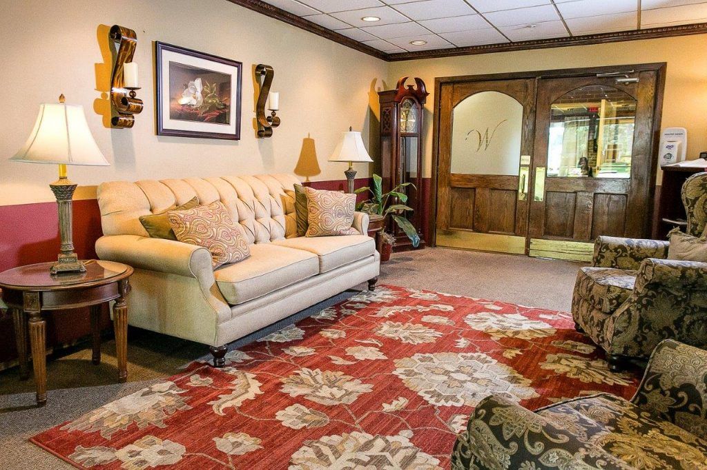 Senior resident relaxing in the cozy living room of Westland A Villa Center with elegant home decor.