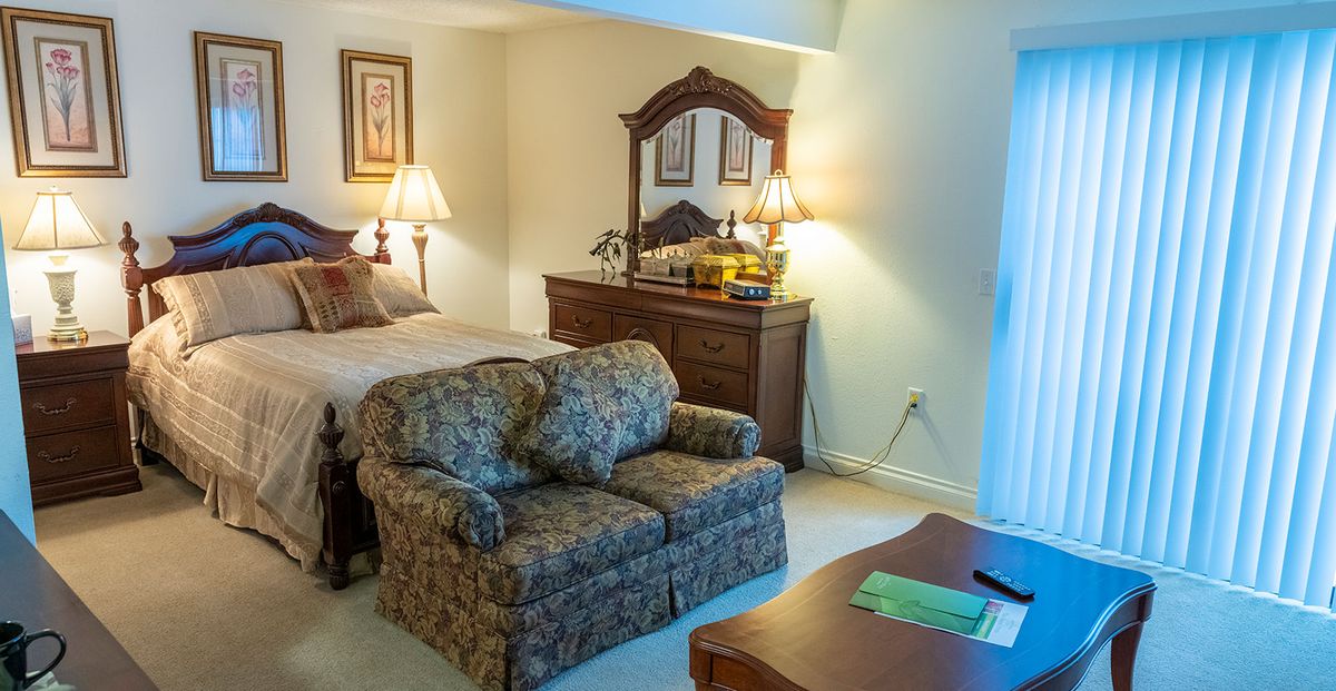Interior view of a bedroom in Camelot senior living community featuring modern decor and furniture.