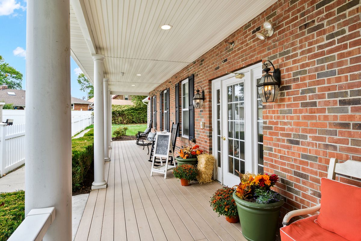 Senior living community at Fox Trail, South River featuring cozy porch with furniture and plants.