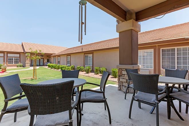 Senior living community, Brookdale East Arbor, featuring a patio with dining table, chairs, and plants.