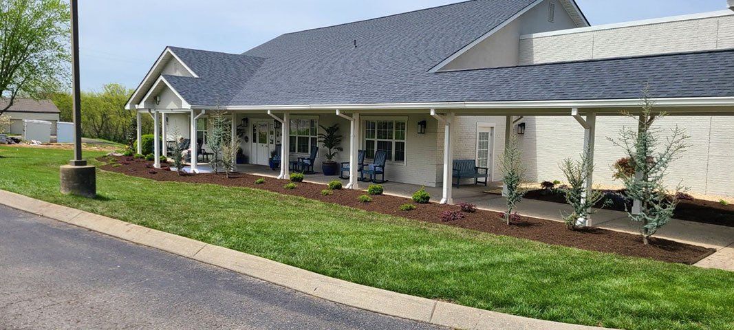 Plant-filled lawn of Legacy Village senior living community in Hendersonville with outdoor furniture.