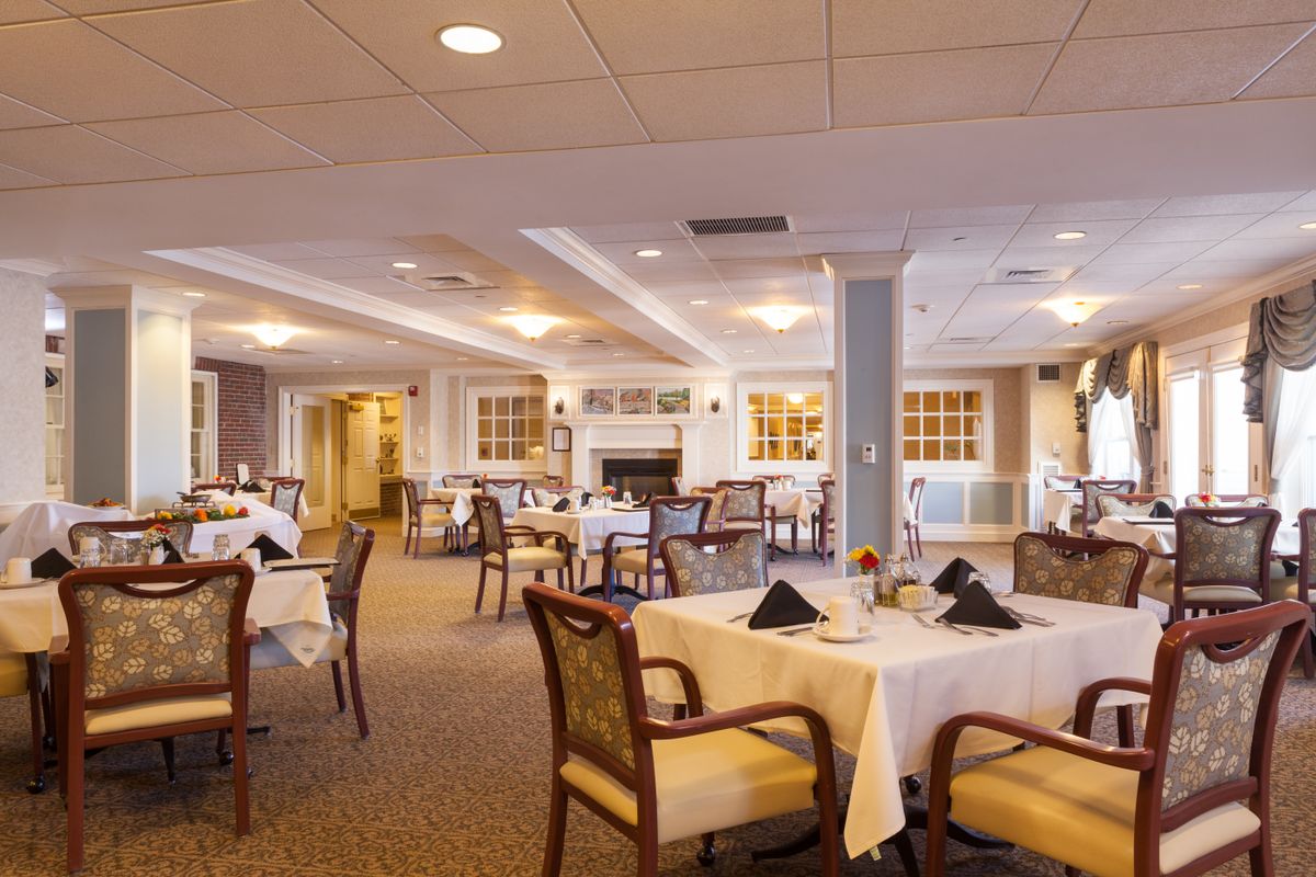 Interior view of Wentworth Senior Living with dining area, reception room, and modern architecture.