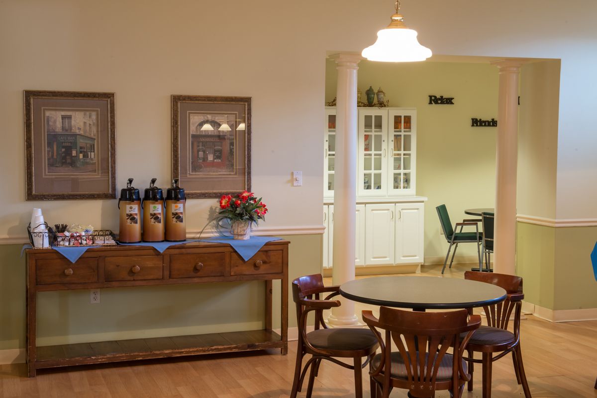 Interior view of Brigham House senior living community featuring a wood-furnished dining room.
