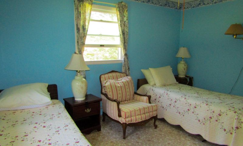 Senior living community bedroom with chair, bed, lamp, and home decor in a dorm-style building.