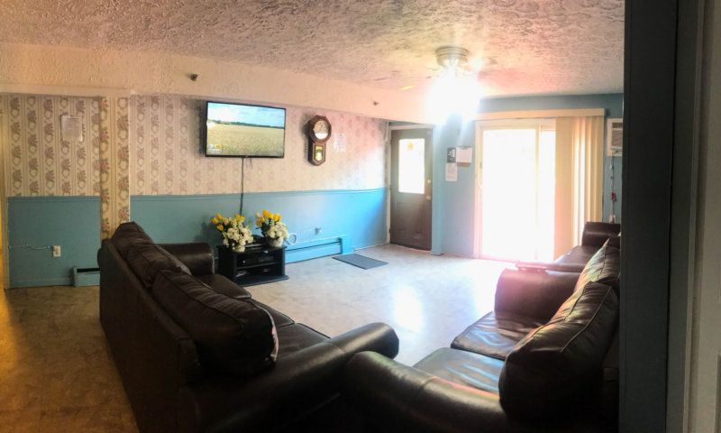 Interior of a senior living community room with modern architecture, furniture, TV, and home decor.