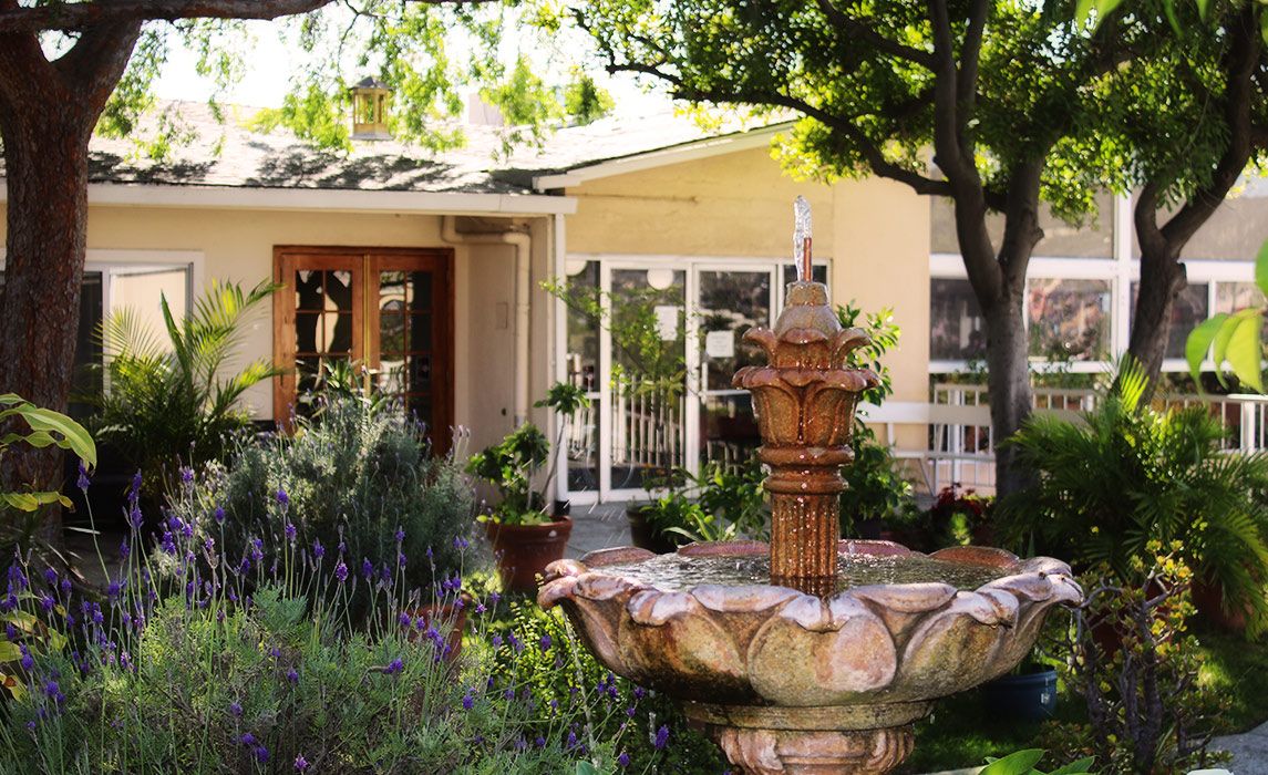 Senior living community, Garden Crest, featuring a fountain, lush gardens, and villa-style housing.