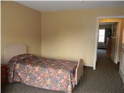 Comfortable bedroom setup at Monticello House senior living community.