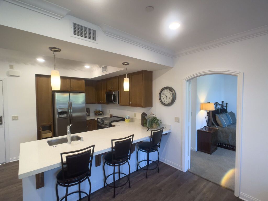 Interior view of Casa Aldea at Carlsbad senior living community featuring dining room, kitchen, and bedroom.