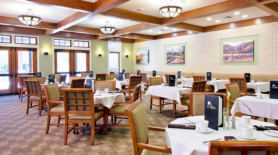 Senior living community Atria Valley View's dining room with tables, chairs, and coffee cups.
