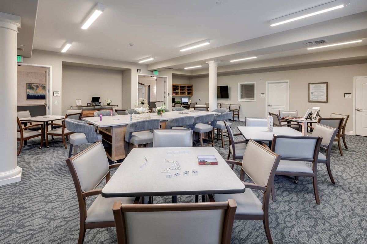Senior living community cafeteria in Laurel Heights with dining furniture and computer monitors.