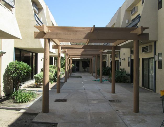 Senior living at Downey Retirement Center featuring urban architecture, housing with patios and pergolas.