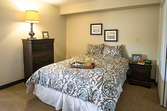 Bedroom interior at Brookdale Dowlen Oaks senior living with bed, art, and furniture.