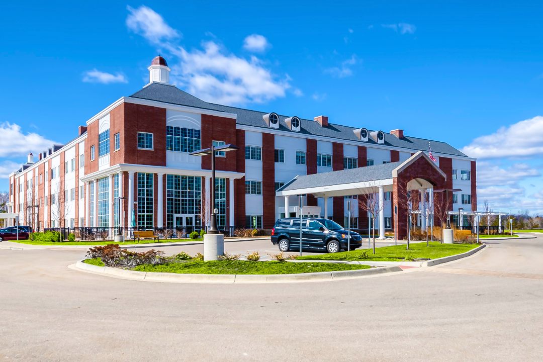 Senior living community, The Avalon of Commerce Township, featuring buildings, cars, and residents.