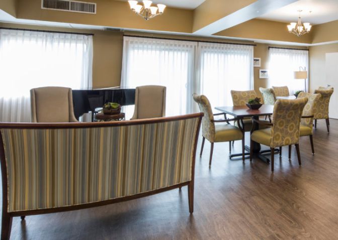 Senior living community at The Groves At Tustin featuring elegant dining room, cozy living area, and hardwood flooring.