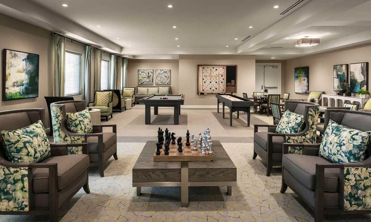 Senior living room interior at HarborChase of Wellington Crossing with chess game on table.