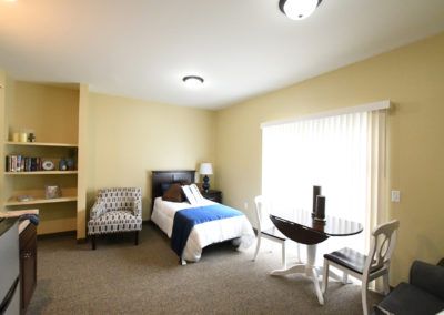 Senior living bedroom at Hampton Manor of Shelby with comfortable furniture and home decor.
