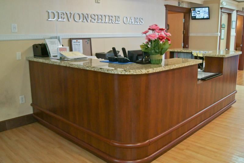 Devonshire Oaks Nursing Center reception area with furniture, computer hardware, and indoor plants.