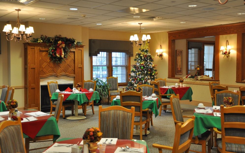 Senior living dining room at The Cliffs At Eagle Rock with festive decor, art and furniture.