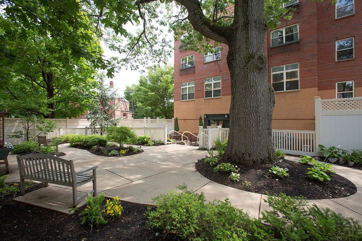 Senior living community at Chestnut Park, Cleveland Circle featuring garden, trees, and city architecture.