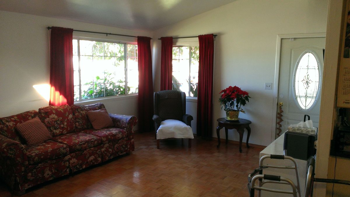 Senior living community interior featuring hardwood flooring, stylish furniture, and floral decor.
