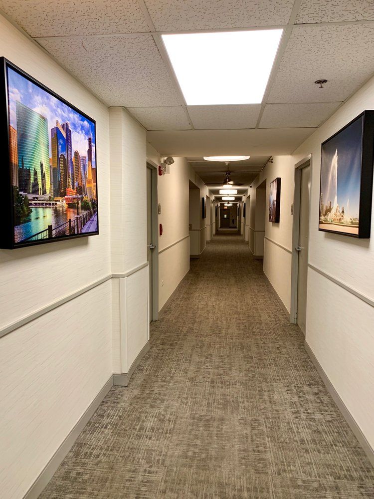 Interior hallway of Jackson Park Supportive Living Facility featuring art paintings and architecture.