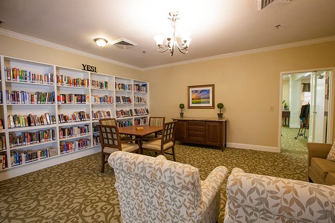 Interior view of Brookdale Sugar Land senior living community featuring library, dining room, and decor.